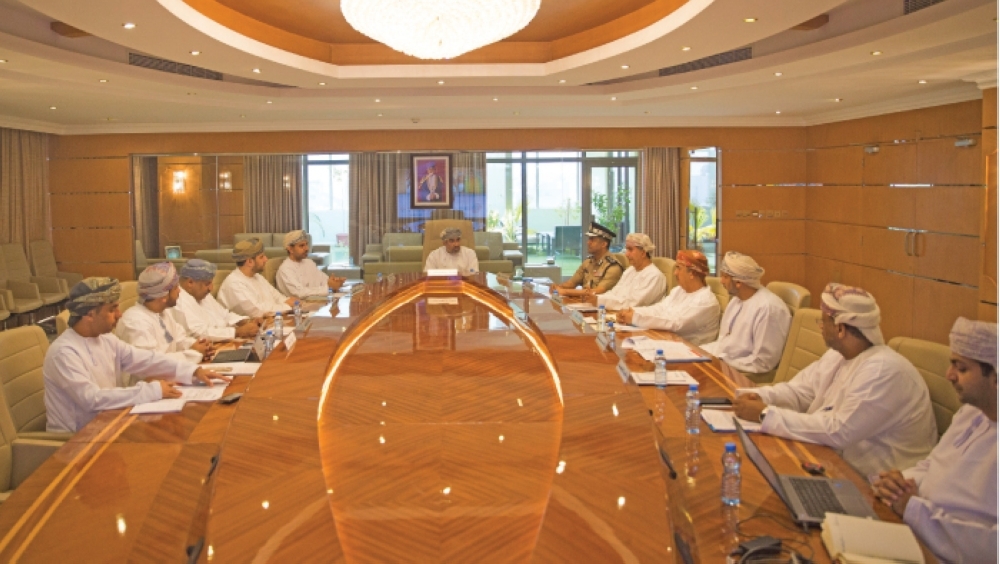 A group of men in traditional Omani dress discuss business around a conference table, reflecting international film.